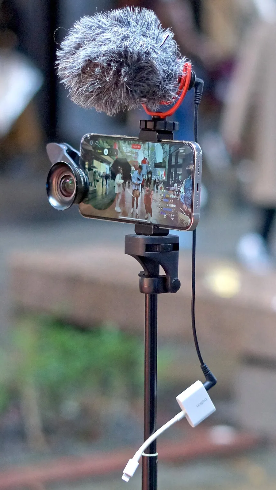 Ponsel terpasang di tripod dengan mikrofon kecil sedang merekam video